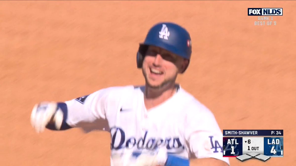 A FOX NLDS broadcast still showing a Los Angeles Dodgers player in a white uniform and blue helmet smiling on the field. The scoreboard shows ATL trailing LAD 1-4 in the 6th inning with 1 out, and pitcher Smith-Shawver at 34 pitches.