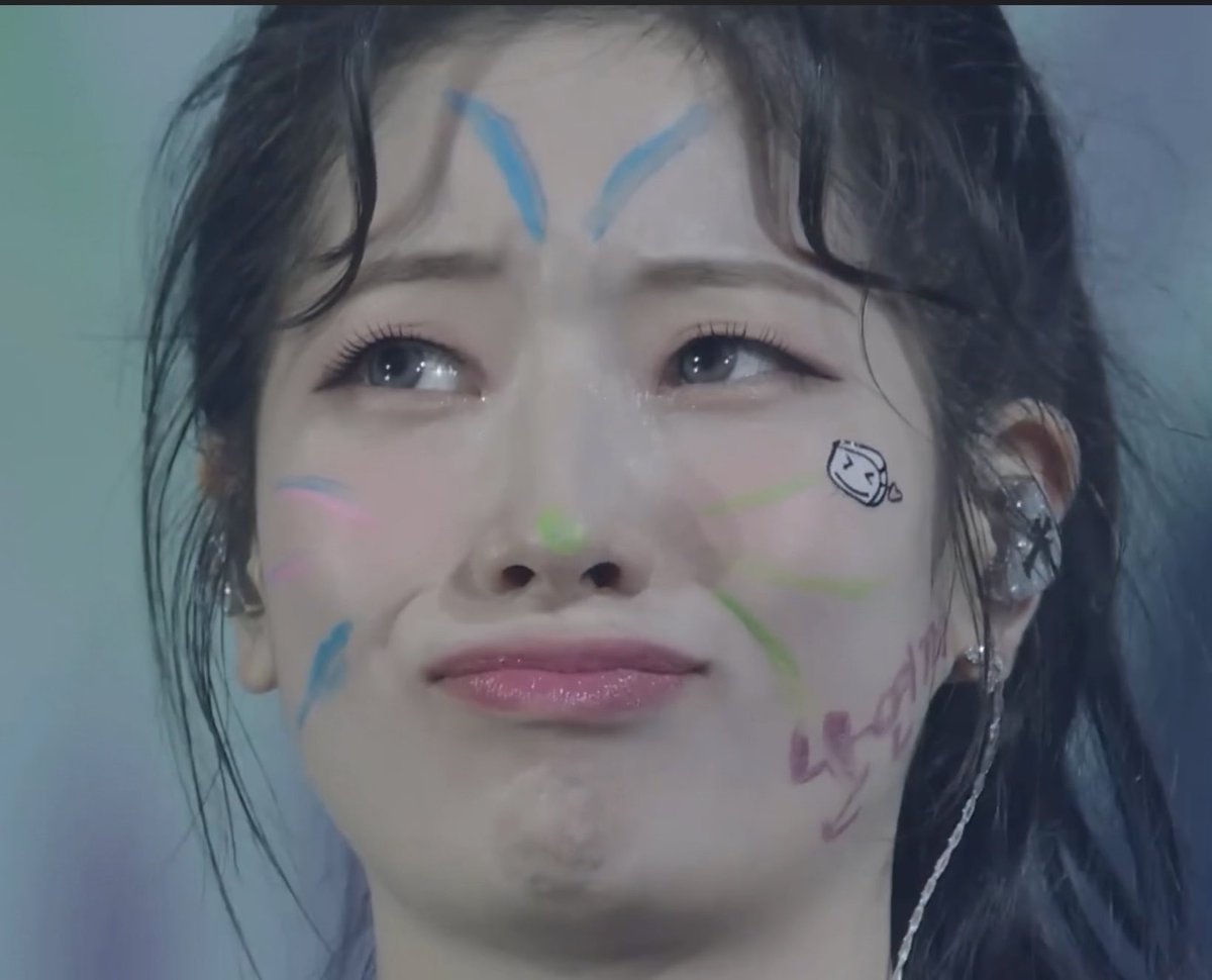 The post is about TWICE member Dahyun, and the image shows her with playful face paint featuring blue, pink, green, and purple designs along with the word "Crystal" written on her cheek, capturing her adorable and fun personality.