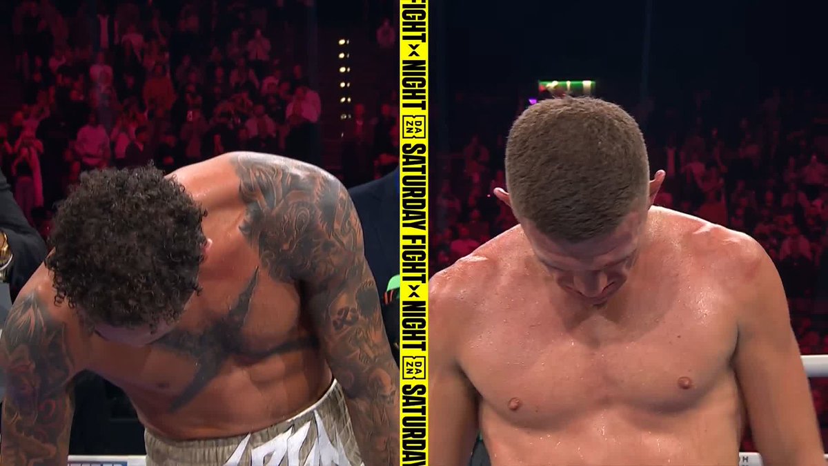 Two boxers stand in the ring, heads bowed, with a yellow "FIGHT NIGHT" banner from DAZN visible between them, following Ben Whittaker's unanimous decision victory over Conor Wallace.