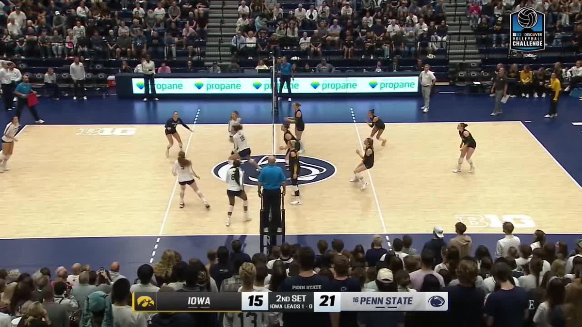 This image shows a volleyball match between Iowa (#15) and #16 Penn State (#21) during the 2nd Set, with Penn State leading Iowa 21-15. Players are positioned at the net mid-play, likely capturing the moment of "Burgdorf with the ROCKET" spike mentioned in the caption, set during the B1G Volleyball Challenge.