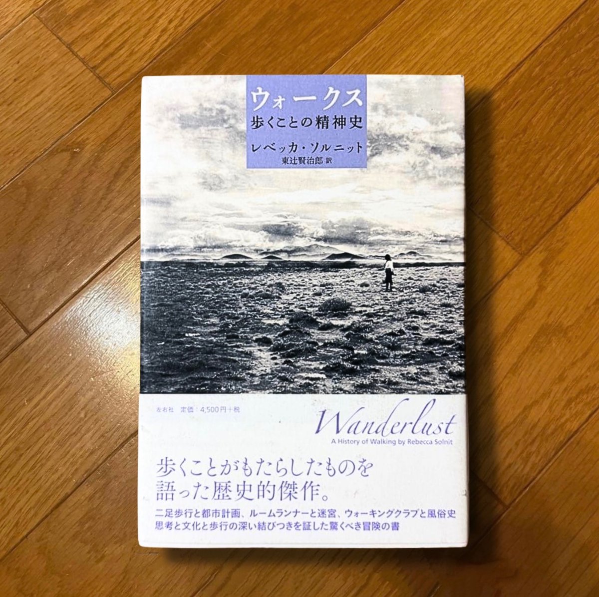 nobushiromasaki's tweet photo. あまりに深すぎる洞察。心が震えた。「歩く」という行為は、時に思考の助けになり、時に権力に立ち向かう運動の表現になった。本書は「ただ歩くこと」が、いつ、どのように、思考や自由や抵抗と結びついたのかをたどった本である。中心にある主張は「時速三マイルの精神」だ。歩く速度は時速およそ3マイル（5キロメートル弱）である。ソルニットによれば、人間の思考もまたこの速度で動いているという。歩いているとき、心と身体と世界が同じ速度で並走している。ようやく会話を始めた人たちのように、身体と心はその速度で互いに揃って機能する。

ところが、現代の生活はこの速度を大きく超えて動いている。これは、実は異様なことである。しかも、当てどもなくぶらぶら歩くことは時に生産的でないとされ、無駄だと見做される。

歩行と思考の結びつきには長い系譜がある。アリストテレスの学派は逍遥学派と呼ばれ、歩きながら講義したとされる。ルソーは『告白』で、足が動いているときにしか頭が働かないと書いた。キルケゴールはコペンハーゲンの街路を自分の応接間のように使い、誰彼となく話しかけながら歩いて思索した。歩行しながら考えたワーズワースの生涯18万マイルの歩行は、この系譜の頂点だ。ソルニットは、歩行が生産志向の社会では「何もしていない」とみなされる行為であることに注目する。何もしていないからこそ、思考がそこで活動できる。労働でも消費でもない時間が、歩行には残されているのだ。

この主張を支える実証もある。スタンフォード大学のマリリー・オペッゾとダニエル・シュワルツが2014年に発表した四つの実験では、座っているときより歩いているときのほうが、発散的思考、つまり一つのものから多くのアイデアを出す課題の成績が参加者の81パーセントで向上した。平均で6割ほどの増加だ（ただし同じ研究は、収束的思考、つまり唯一の正答に絞り込む課題では、歩行が成績を下げることも示している。歩けば頭が良くなる、という一般化はできない）。ワーズワースが歩きながら詩句をスケッチし、のちに机に向かいながら推敲したのは、この区別を身体で知っていたからだと言える。

ちょっと脱線する。

人類学者のティム・インゴルドが「地面の上の文化」で論じたことを紹介したい。すなわち、西洋の知は靴と椅子と舗道によって身体を地面から切り離すことを制度化してきたのだと。手は知性の器官、足はただの移動の器官という二分法はその切断の産物である。インゴルドは、足で世界を知覚する文化が世界中にあることを示し、頭だけで考えるという西洋の自己像を疑った。ソルニットの本は、この疑いを西洋の内部から、歩いた人々の系譜として書き直したものとして理解できる。

まさに第二部でソルニットが描くのは、「風景を見るために歩く」という文化の発明だ。18世紀まで、歩くことは貧しさの印だった。馬車に乗れない者が歩かざるを得ないように。ところが、ロマン主義がこれを逆転させる。整形された庭園から風景式庭園へ、庭園から原野へと、歩く場所が外へ外へと広がり、登山やウォーキングクラブも生まれた。第十章では、1932年のキンダー・スカウト集団侵入事件、つまり英国の労働者たちが貴族の私有地に大挙して立ち入り、歩く権利を要求した出来事が描かれる。歩く権利は、土地の所有権と正面から衝突する政治的な権利でもあった。「ここから先は立ち入り禁止」と権利によって街が侵食される中、歩行の権利のために人々は戦った。

また、ディケンズの夜の徘徊、ホイットマンの群衆、ヴァージニア・ウルフの街歩きのように、都市では別の変化も生まれる。パリではボードレールが描き、ベンヤミンが理論化したフラヌール、つまり群衆の中を目的なく漂う遊歩者が登場する。ソルニットはさらに、ミシェル・ド・セルトーが1980年の『日常的実践のポイエティーク』で論じた「都市を歩く」を引用する。都市計画者は上から都市を見下ろし、歩行者は下から都市を書く。計画された道を無視して近道をし、立ち止まり、引き返す歩行者の足取りは、都市に対する無数の小さな抵抗である。デモ行進や革命の行進もこの延長にある。歩くことは、公共空間を身体で主張する行為なのだ。

さらに、第十四章「夜歩く」は、本書で最も刺激的な章だと思った。女性が一人で歩くことは、歴史的に「ストリートウォーカー」、つまり娼婦と同一視されてきた。夜の公共空間から女性が排除されてきたのは、法律によってではなく、この連想とそれが正当化する暴力によってだった。男性のフラヌールが享受した匿名の自由は、女性には与えられなかったのだ。ソルニットはここで、歩く自由が普遍的な人間の自由ではなく、特定の身体に許された自由だったことを暴く。この批判は、2016年にガーネット・カドガンが「黒人として歩く」というエッセイで、黒人男性にとってフラヌール的な自由が成立しないことを論じた議論にもつながる。誰が、どこを、何時に「怪しまれずに」歩けるか。それが社会の権力配分の最も日常的な指標になる。

ところが──近代以降、歩行は消滅してきている。郊外化と自動車が、日常から歩く理由を奪った。人々は家から車で出かけ、ジム、職場、店という、互いに切り離された室内を渡り歩くように暮らしている。足で移動していれば、それらはすべて連続的につながっていた。それが、まるで舞台の場面転換のようになってしまった。ジムのトレッドミルで歩く人々を、ソルニットは「有酸素運動のシーシュポス」と呼ぶ。移動のない歩行。失われた歩行の代償としての歩行である。彼女はラスベガスにも触れる。世界の名所を一本の通りに圧縮して、移動せずに世界を見た気分にさせる場所として本書の議論の収斂点としてラスベガスを描く。

これが極まったがゆえに、リチャード・ロングが草原を往復して踏み跡だけを残した作品『歩くことで作られた線』や、マリーナ・アブラモヴィッチとウーライが万里の長城の両端から歩いて中央で別れた行為など、歩行そのものをまとめたものが美術品として扱われるようになった。歩くことが「何もしていない」とみなされる社会でこそ、歩くことがそのまま表現になるのである。

新たな創造性の種といえば聞こえがいいけれど、それらの作品が作品たり得る理由にも目を向けたいと思った。

きょうび、歩行は「設計されるもの」になった。かつて歩行は設計以前の「ただそこにあるもの」だった。それが失われたからこそ、いま歩行者空間は都市において「整備」される。また、整備された歩行者空間は、歩行の自由、つまり計画を無視して近道をし、夜に一人で歩き、群衆となって抗議的に行進する自由をどこまで許容するだろうか。このような問題が新たに立ち上がる。

歩きやすい街と自由に歩ける街は、同じではない。前者は設計で作れるが、後者は設計の隙間にしか生まれない。本書が最後に問いかけるのは、この二つのあいだの距離である。

『ウォークス 歩くことの精神史』レベッカ・ソルニット、東辻賢治郎訳、左右社