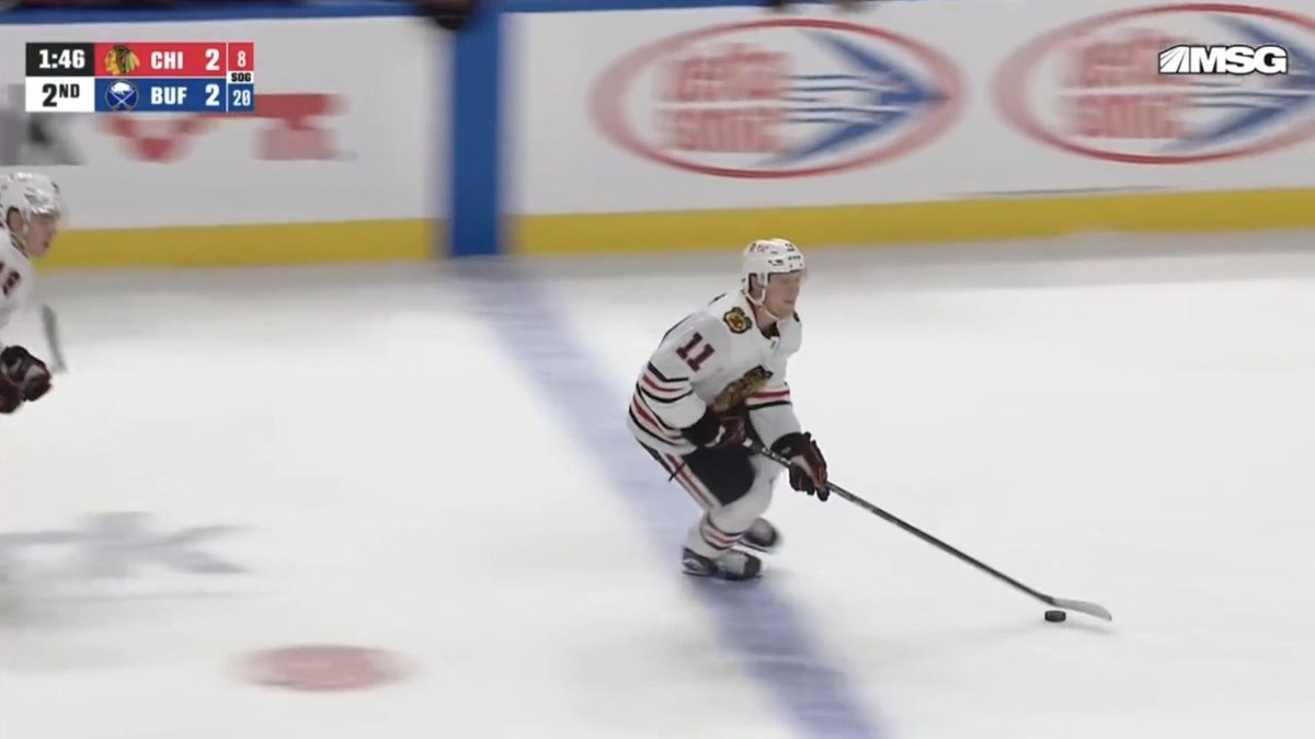 A Chicago Blackhawks player wearing #11 skates with the puck up the ice after the Sabres' power play ended, with the scoreboard showing CHI 2, BUF 2 at 1:46 in the 2nd period. The image captures the moment just before the Blackhawks reclaim their lead as the penalty expires.