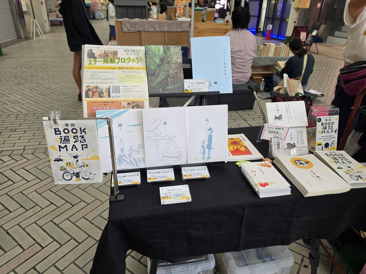 yukarinu2's tweet photo. BOOK WEEKEND始まりました！アーケード商店街なので雨でも大丈夫！本屋さん大集合。「BOOK遍路をつくる会」は田町商店街の漢方薬専門店の前あたりです。予約制古書店「な夕書」のキキさんが「IKUNAS」の『本とともに。』特集号を押し売りに来た！ルヌガンガさんや
古本YOMSさんも見開きで
掲載。#本 https://t.co/PVEAbUWSKx