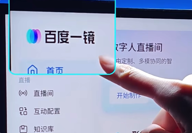 A close-up of a finger pointing at a digital interface displaying the logo and Chinese text '百度一镜', with menu options including '首页', '直播', '直播间', '互动配置', and '知识库' visible.