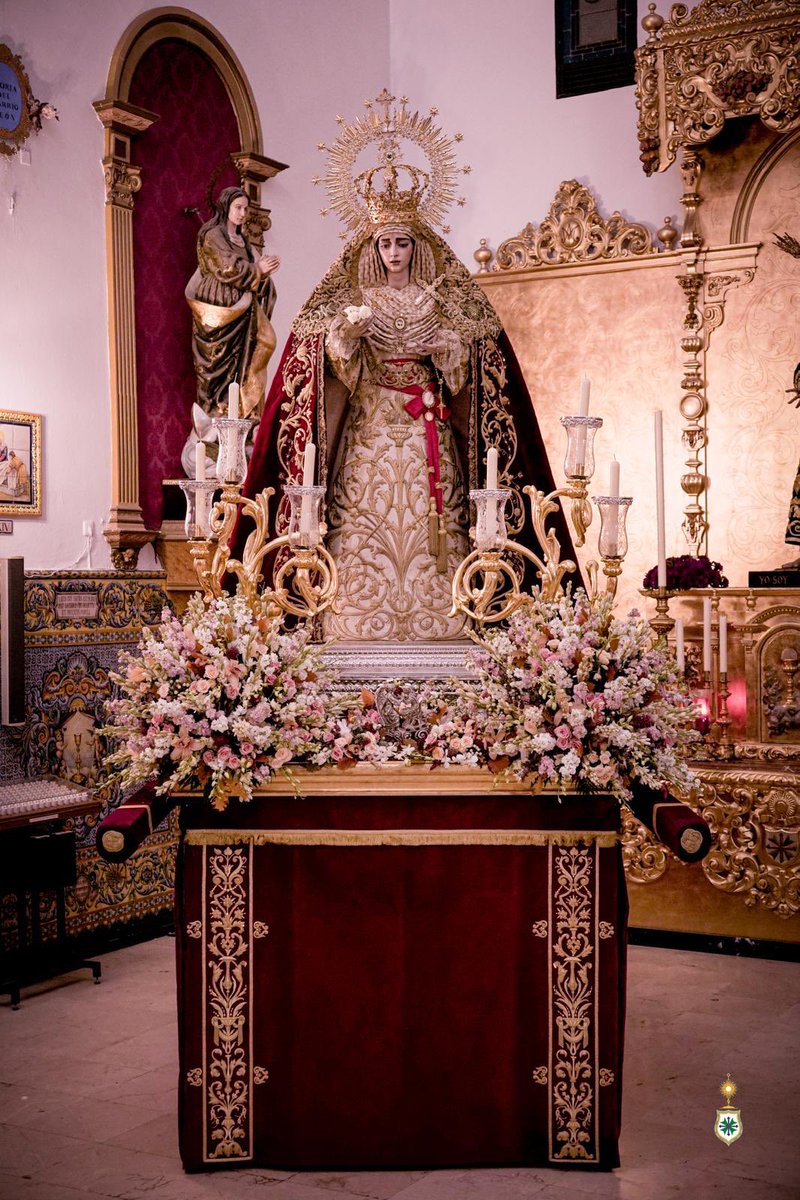 HdadSanGonzalo's tweet photo. ⚪️ HERMANDAD | ROSARIO DE LA AURORA

⛪️ Hoy, domingo 4 de octubre, a las 07:30 horas, Nuestra Señora de la Salud volverá a pisar las calles de su Barrio León. Un barrio que ya la espera para acompañarla en Solemne “Rosario de la Aurora”.

⛲️ La Virgen de la Salud luce para esta ocasión:

☑️ Corona de la Coronación, de plata de ley y oro, obra conjunta de Fernando Marmolejo Camargo (1967) y Fernando Marmolejo Hernández (2017).

☑️ Manto de terciopelo rojo con bordados en oro a realce en el Taller Nuestra Señora de la Paz -regentado por el bordador Leopoldo Padilla Viss- en 1960 que proceden del primer techo de palio, pasados a esta prenda en el Taller de Garduño en 2004.

☑️ Toca de sobremanto de malla de oro bordada en el mismo metal, en el Taller Nuestra Señora de la Esperanza, de Carrasquilla (1975).

☑️ Fajín de Brigada, ofrendado por el General D. Juan Carlos Varas Criado (2004), de seda roja en punto español con bordados en oro en los entorchados.

☑️ Puñal de plata de ley sobredorada, obra del taller de Villarreal (1964).

☑️ Alfiler nominativo «Salud», en oro de ley, regalo de las Hermandades del Lunes Santo (1986).

☑️ Rosario de oro de ley, ofrendado por una hermana (1967).

☑️ Camafeo de la Fuente de la Salud, del siglo XIX, realizado en espuma de mar y oro, ofrendado por un devoto con motivo de la Coronación Canónica (2017).

☑️ Juego de tres azahares de oro de ley, ofrenda del Cuerpo de Acólitos con motivo de la Coronación, obra de Joyería La Victoria, de Coria del Río (2017).

☑️ Tocado de otomán original del siglo XIX, de hojilla de plata con detalles en oro, adquirido en un anticuario y donado por un hermano en 2026.

☑️ Pañuelo de encaje francés del siglo XIX, ofrendado por un hermano.

☑️ Camafeo de marfil de Nuestra Señora de la Esperanza, donado por la vecina y querida Hermandad del mismo nombre con motivo de la Coronación.

☑️ Medalla de oro de la Virgen Milagrosa, regalo de la Asociación del mismo nombre de nuestra Parroquia con motivo de la Coronación.

☑️ Alfiler infinito de perlas y oro, ofrendado por un hermano.

☑️ Medalla de la Ciudad, de plata sobredorada, concedida por el Ayuntamiento de Sevilla con motivo de la Coronación, obra de Fernando Marmolejo Hernández.

☑️ Pulsera de oro y brillantes de Cartier.

☑️ Escudo de la Hermandad, ofrendado por la Junta de Gobierno, obra de Joyería Oliva (2012).

🤍 La Hermandad de San Gonzalo expresa su más sincero agradecimiento a su vestidor, D. Antonio Bejarano @abejaranito, a su Diputación de Cultos, a sus Priostes y Camareras, por la devoción y el amor que entre sus manos nos ofrecen radiante a Nuestra Señora de la Salud.

✝️ Salud de los enfermos, ruega por nosotros.

📸 @apuelles25 

#SGRosarioSalu26