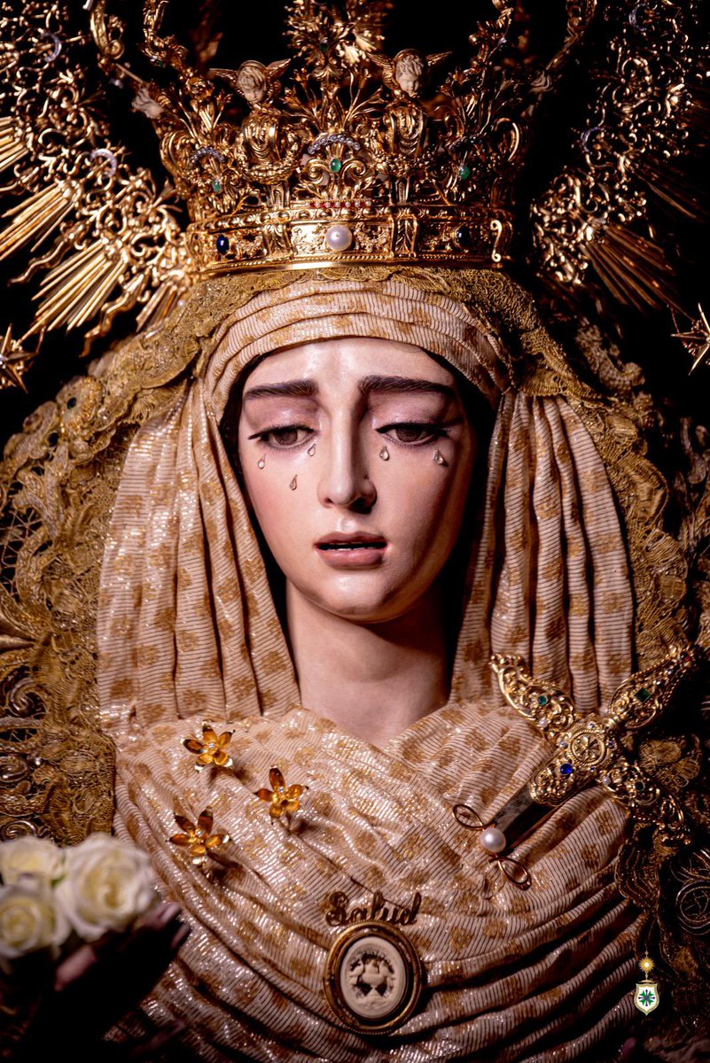 HdadSanGonzalo's tweet photo. ⚪️ HERMANDAD | ROSARIO DE LA AURORA

⛪️ Hoy, domingo 4 de octubre, a las 07:30 horas, Nuestra Señora de la Salud volverá a pisar las calles de su Barrio León. Un barrio que ya la espera para acompañarla en Solemne “Rosario de la Aurora”.

⛲️ La Virgen de la Salud luce para esta ocasión:

☑️ Corona de la Coronación, de plata de ley y oro, obra conjunta de Fernando Marmolejo Camargo (1967) y Fernando Marmolejo Hernández (2017).

☑️ Manto de terciopelo rojo con bordados en oro a realce en el Taller Nuestra Señora de la Paz -regentado por el bordador Leopoldo Padilla Viss- en 1960 que proceden del primer techo de palio, pasados a esta prenda en el Taller de Garduño en 2004.

☑️ Toca de sobremanto de malla de oro bordada en el mismo metal, en el Taller Nuestra Señora de la Esperanza, de Carrasquilla (1975).

☑️ Fajín de Brigada, ofrendado por el General D. Juan Carlos Varas Criado (2004), de seda roja en punto español con bordados en oro en los entorchados.

☑️ Puñal de plata de ley sobredorada, obra del taller de Villarreal (1964).

☑️ Alfiler nominativo «Salud», en oro de ley, regalo de las Hermandades del Lunes Santo (1986).

☑️ Rosario de oro de ley, ofrendado por una hermana (1967).

☑️ Camafeo de la Fuente de la Salud, del siglo XIX, realizado en espuma de mar y oro, ofrendado por un devoto con motivo de la Coronación Canónica (2017).

☑️ Juego de tres azahares de oro de ley, ofrenda del Cuerpo de Acólitos con motivo de la Coronación, obra de Joyería La Victoria, de Coria del Río (2017).

☑️ Tocado de otomán original del siglo XIX, de hojilla de plata con detalles en oro, adquirido en un anticuario y donado por un hermano en 2026.

☑️ Pañuelo de encaje francés del siglo XIX, ofrendado por un hermano.

☑️ Camafeo de marfil de Nuestra Señora de la Esperanza, donado por la vecina y querida Hermandad del mismo nombre con motivo de la Coronación.

☑️ Medalla de oro de la Virgen Milagrosa, regalo de la Asociación del mismo nombre de nuestra Parroquia con motivo de la Coronación.

☑️ Alfiler infinito de perlas y oro, ofrendado por un hermano.

☑️ Medalla de la Ciudad, de plata sobredorada, concedida por el Ayuntamiento de Sevilla con motivo de la Coronación, obra de Fernando Marmolejo Hernández.

☑️ Pulsera de oro y brillantes de Cartier.

☑️ Escudo de la Hermandad, ofrendado por la Junta de Gobierno, obra de Joyería Oliva (2012).

🤍 La Hermandad de San Gonzalo expresa su más sincero agradecimiento a su vestidor, D. Antonio Bejarano @abejaranito, a su Diputación de Cultos, a sus Priostes y Camareras, por la devoción y el amor que entre sus manos nos ofrecen radiante a Nuestra Señora de la Salud.

✝️ Salud de los enfermos, ruega por nosotros.

📸 @apuelles25 

#SGRosarioSalu26