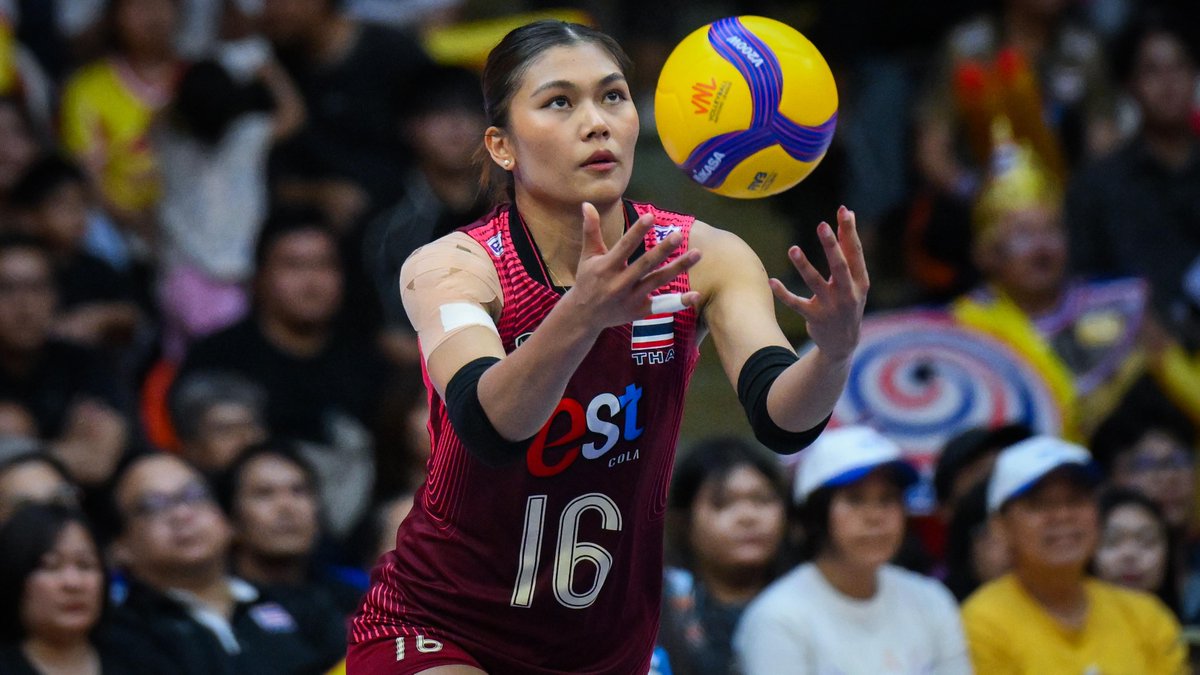 Thailand's #16, Pimpichaya Kokram, focuses intently on setting the ball during a national team match, wearing the red Thai jersey with "est COLA" sponsorship as she prepares for her next move to LOVB Atlanta.