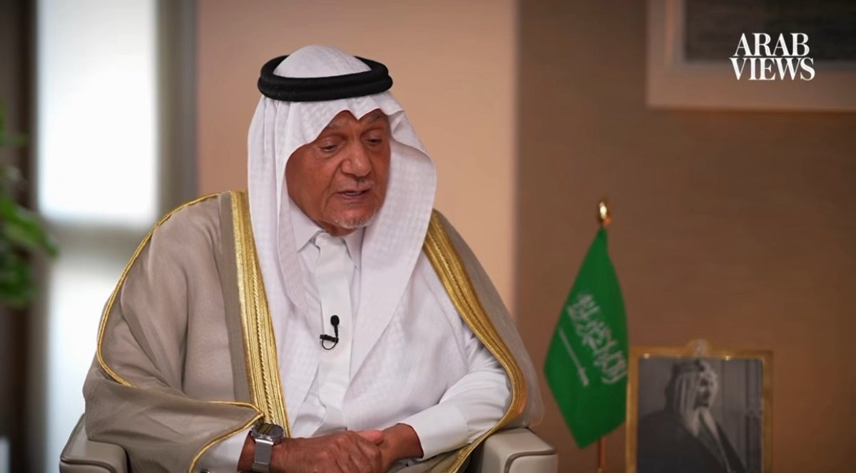 An elderly man in traditional Saudi attire (white thobe and ghutra with black agal) appears to be giving an interview, with a Saudi flag and framed portrait visible behind him and the "ARAB VIEWS" logo in the top right corner. The image likely relates to the post as the speaker appears to be a Saudi official or commentator offering his perspective on the Saudi-Iran agreement mediated by China.