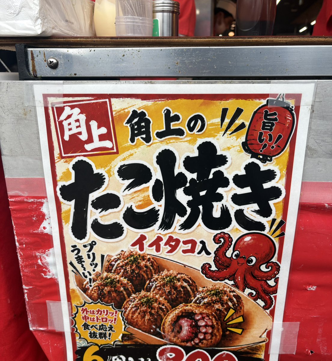 sizu14's tweet photo. イイダコが丸ごと入ったたこ焼き美味しかった🐙！
だけどポスターがAIで少々不気味 https://t.co/YnQLUf72ci