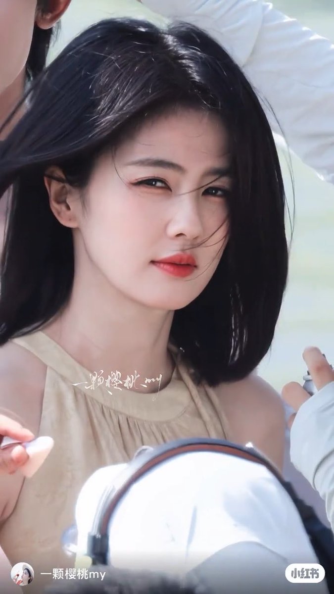 A woman with a short black bob haircut and red lipstick looks back over her shoulder with a slight smile, with Chinese text overlaid on the image and a Xiaohongshu watermark at the bottom.