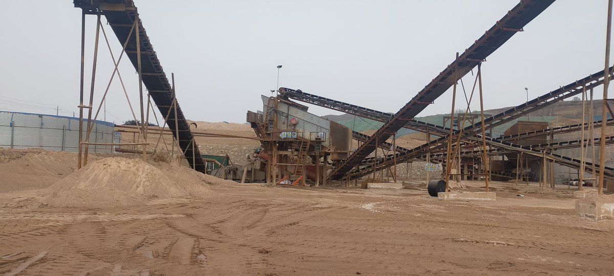 N8aDQpfLiGyfIkQ's tweet photo. [At the construction site, a heavy sieve is filtering sand, with a pile of materials and a woven fence nearby under the sun.]， https://t.co/7KVLKaYTIn