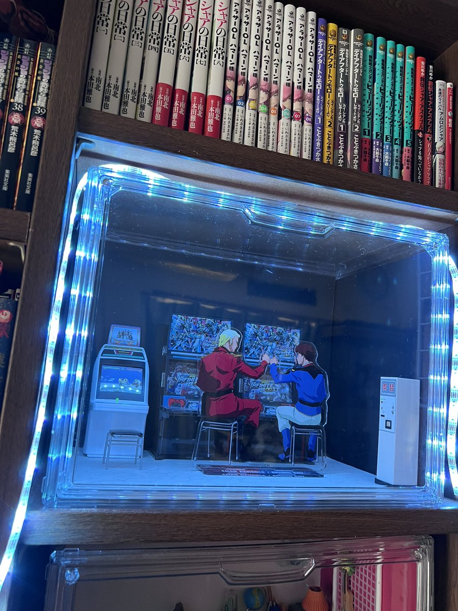 hisibosi's tweet photo. ゲーセンっぽくするには壁を暗くしてライトで照らしたら良いのでは、ってコメントが多かったので、とりあえず100均で黒の色紙とテープライト買ってきてみた。キラキラしてここだけ雰囲気が違くて絵面が面白い。楽しい🤣 https://t.co/snnGCvbplM