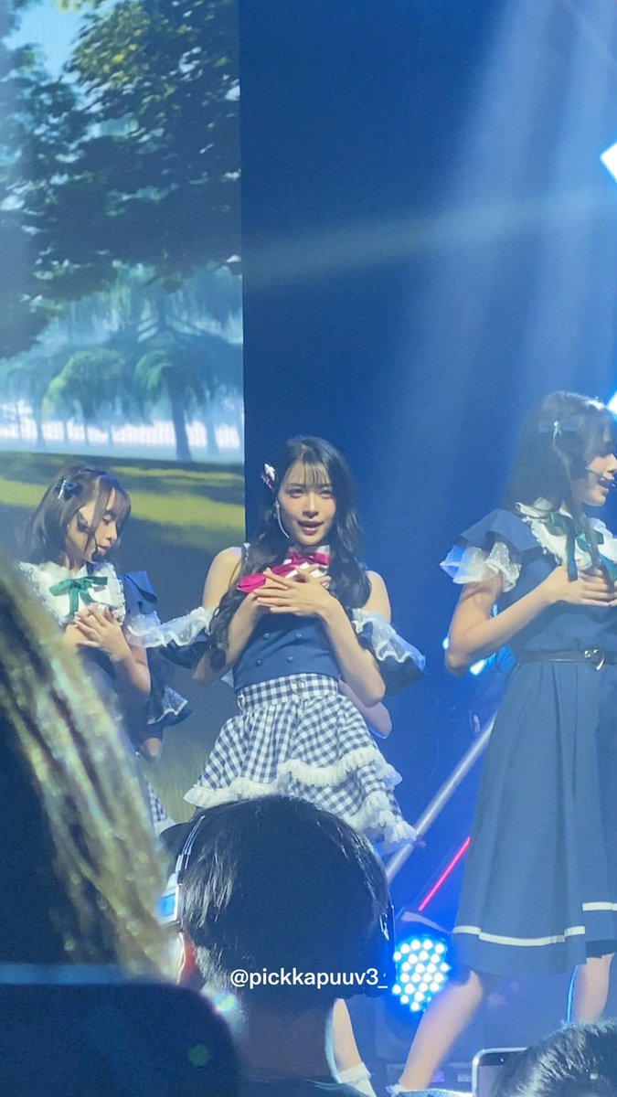 Three female performers in matching blue and white frilly outfits perform on stage under bright spotlights, with a watermark '@pickkapuuv3'.