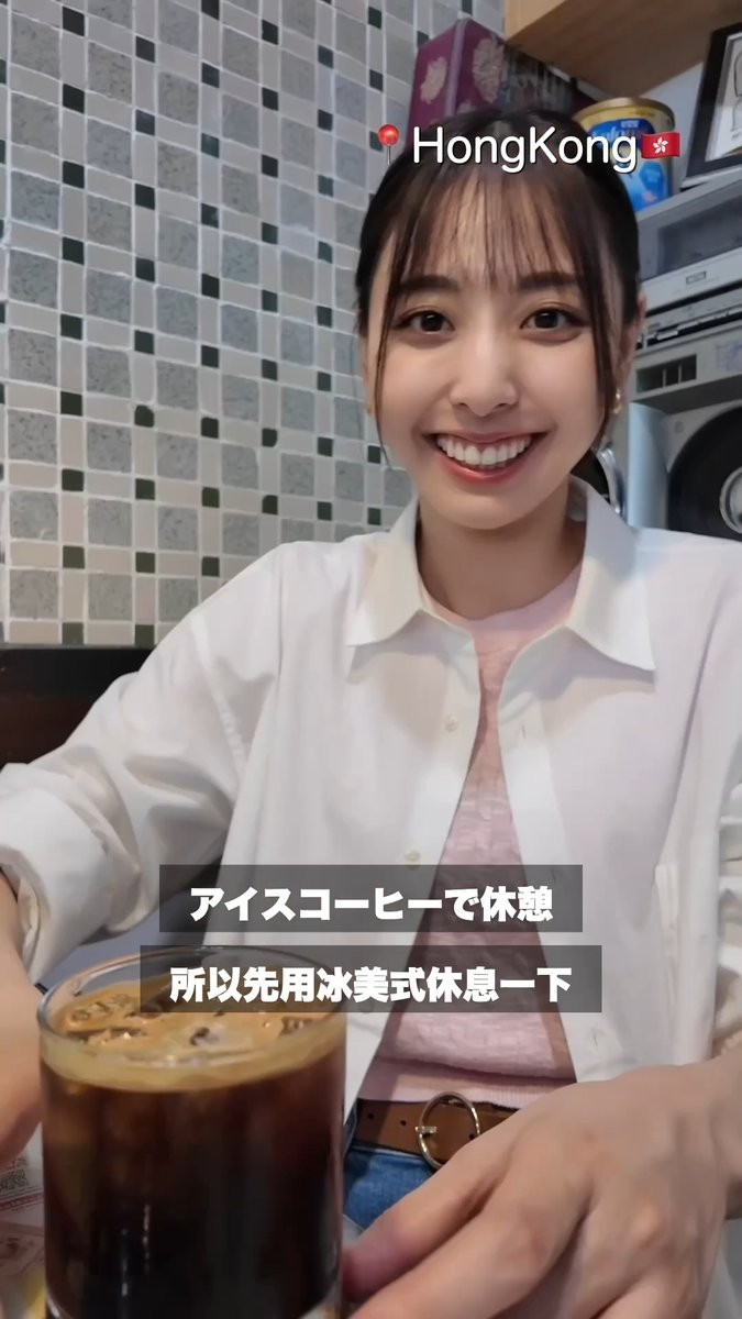 A woman smiles at the camera while holding an iced coffee, with text reading 'HongKong', 'アイスコーヒー で休憩', and '所以先用冰美式休息一下' overlaid.
