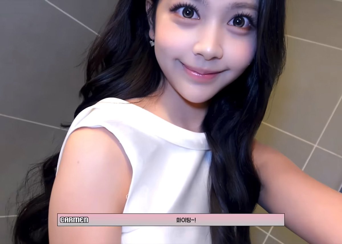 A young woman with long dark hair smiles at the camera, wearing a white sleeveless top with text overlay reading 'CARMEN' and '화이팅~!'.