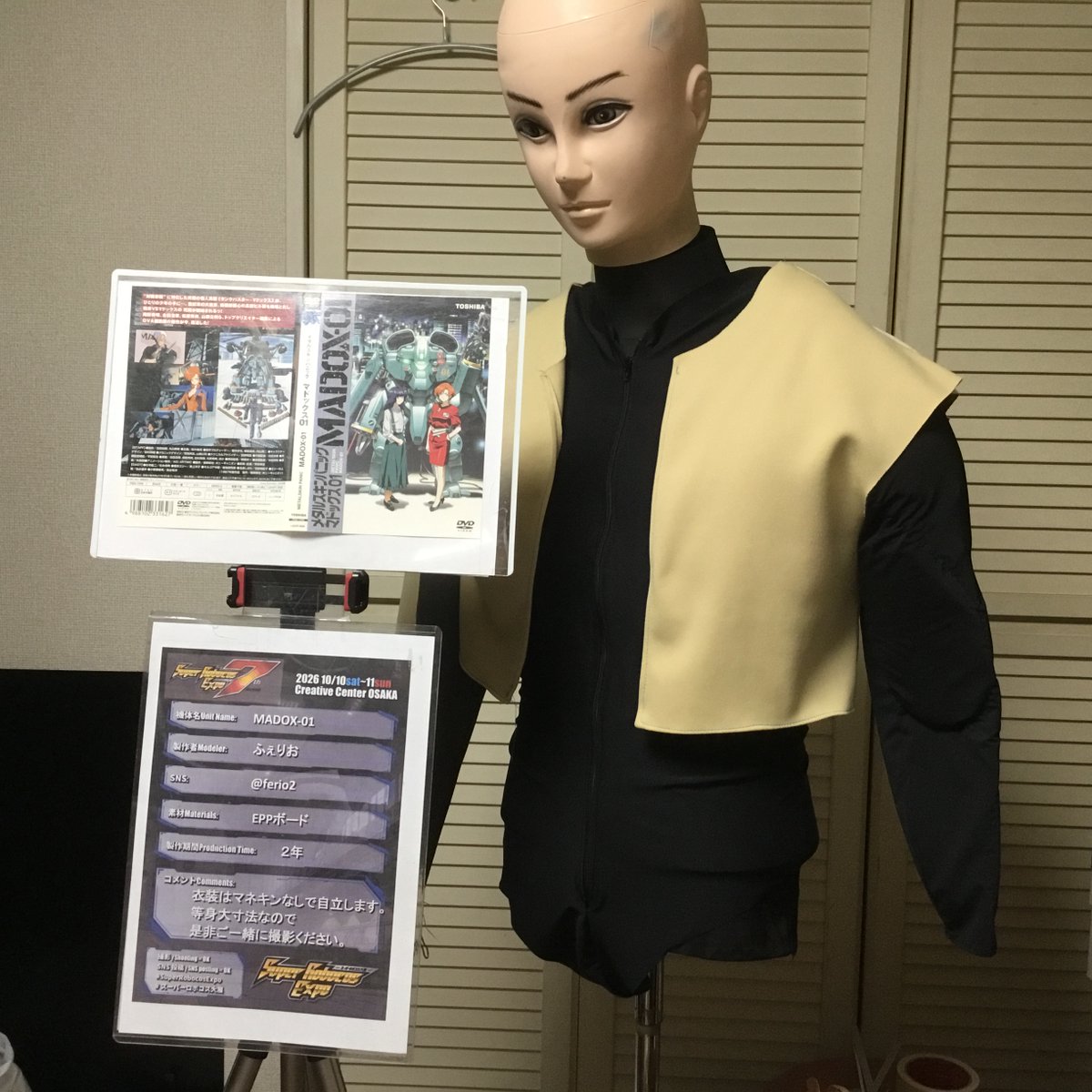 ferio2's tweet photo. ロボコス大展用の展示プレートを三脚で目線の位置に固定しました。
元ネタが1987年の作品なので、分かってもらえるようにDVDのパッケージも付けておきます。
これなら等身大製作であることも一目で分かってもらえて一石二鳥かと。
📷：たけくるさん
#superrobocosexpo 
#スーパーロボコス大展 https://t.co/u9i7mHg0SC