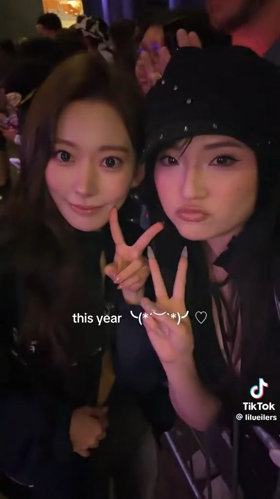 A TikTok screenshot showing two women making peace signs in a dark venue, with text overlay "this year ╮(╯▽╰)╭ ♡" and the handle @lilueilers.