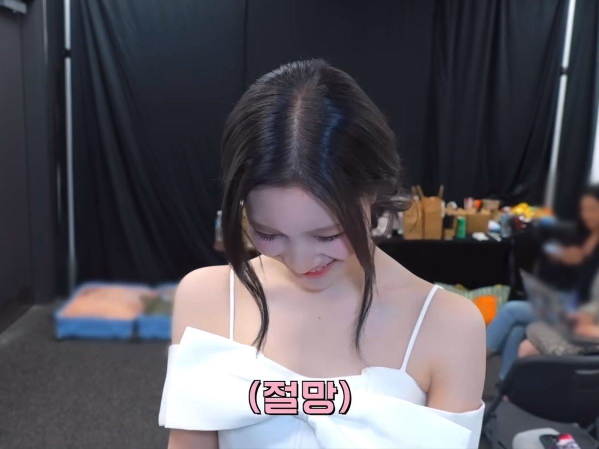 A young woman with dark hair, wearing a white off-shoulder dress, looks downward with a shy, blushing smile, appearing flustered and bashful. The Korean caption "(절망)" translates to "(Despair)," humorously expressing her overwhelmed reaction to the sweet compliments in the post.