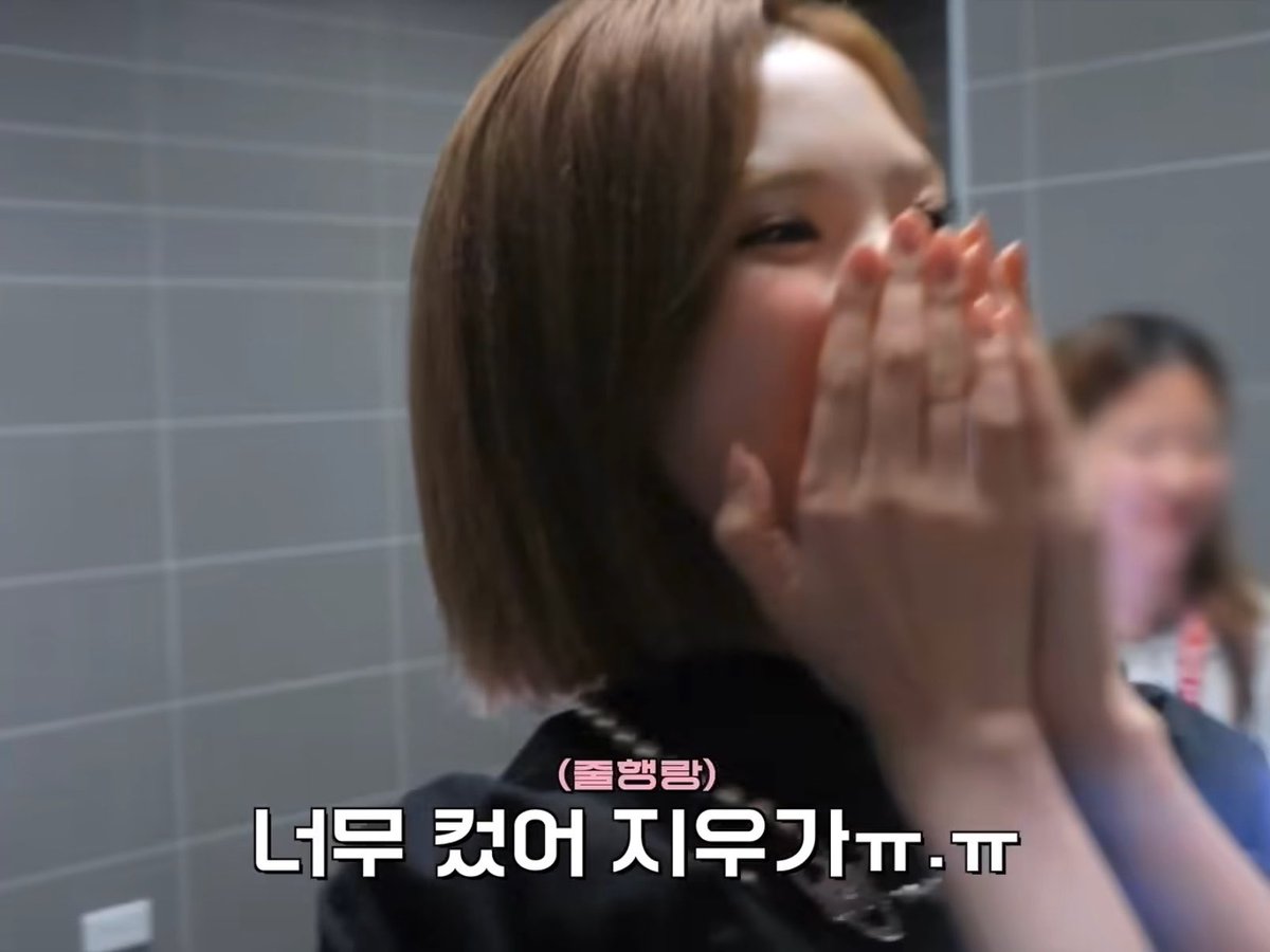 A young woman with short brown hair covers her face with her hands while laughing, with Korean subtitles reading "(둘람탱)" and "너무 컸어 지우가ㅠ.ㅠ" (It was too big, Jiwon ㅠ.ㅠ). The image captures a candid moment of someone reacting playfully, matching the post's context about a fun challenge with Winter (sbn) where things went unexpectedly "too big."