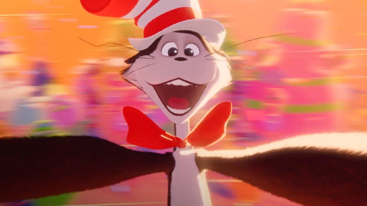 An animated cat character wearing a tall red and white striped hat and a red bowtie has its arms outstretched in front of a vibrant, colorful streaked background.