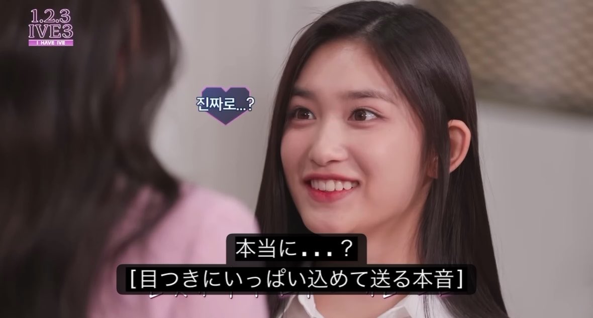 A screenshot from the show "1,2,3 IVE3 - I HAVE IVE -" featuring a smiling young woman looking at another person, with Japanese subtitles reading "진짜로...?" (Really...?), "本当に...?" (Really...?), and "[目っきにいっぱい込めて送る本音]" ([Her true feelings sent with a lot of feeling in her eyes]).