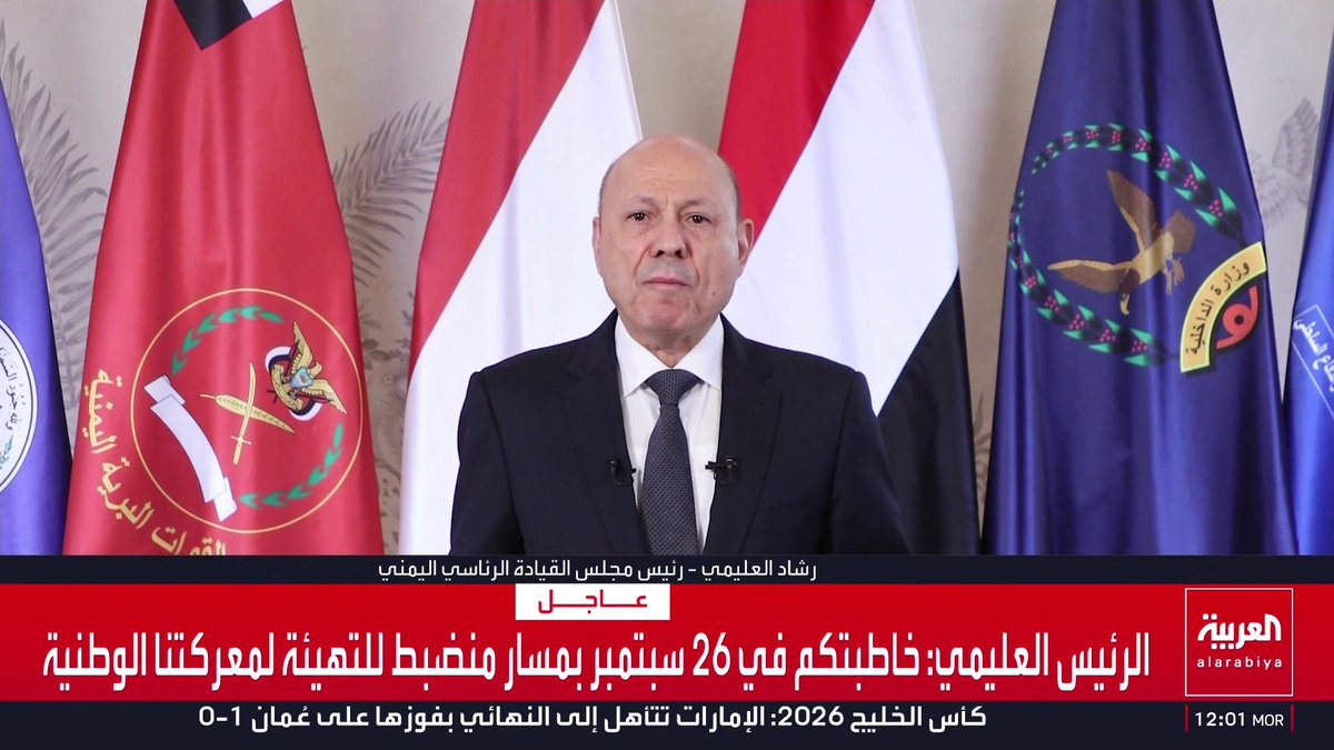 The image shows a stern-looking man in a dark suit and tie delivering a televised address, flanked by Yemeni flags and presidential emblems, with the Al Arabiya news ticker displaying his statement about preparing for "our national battle" since September 26 and transitioning from preparation to action to restore the state. The broadcast context aligns with the post's description of the Yemeni Presidential Leadership Council's chairman addressing the nation on a strategic path forward.