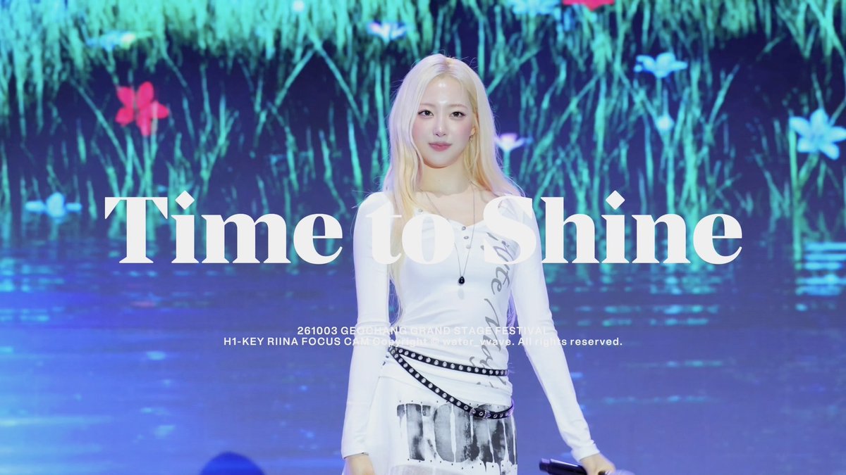 A K-pop performer with blonde hair stands on stage at the '261003 GEOCHANG GRAND STAGE FESTIVAL,' with overlaid text reading 'H1-KEY RIINA FOCUS CAM' and 'Time to Shine'.