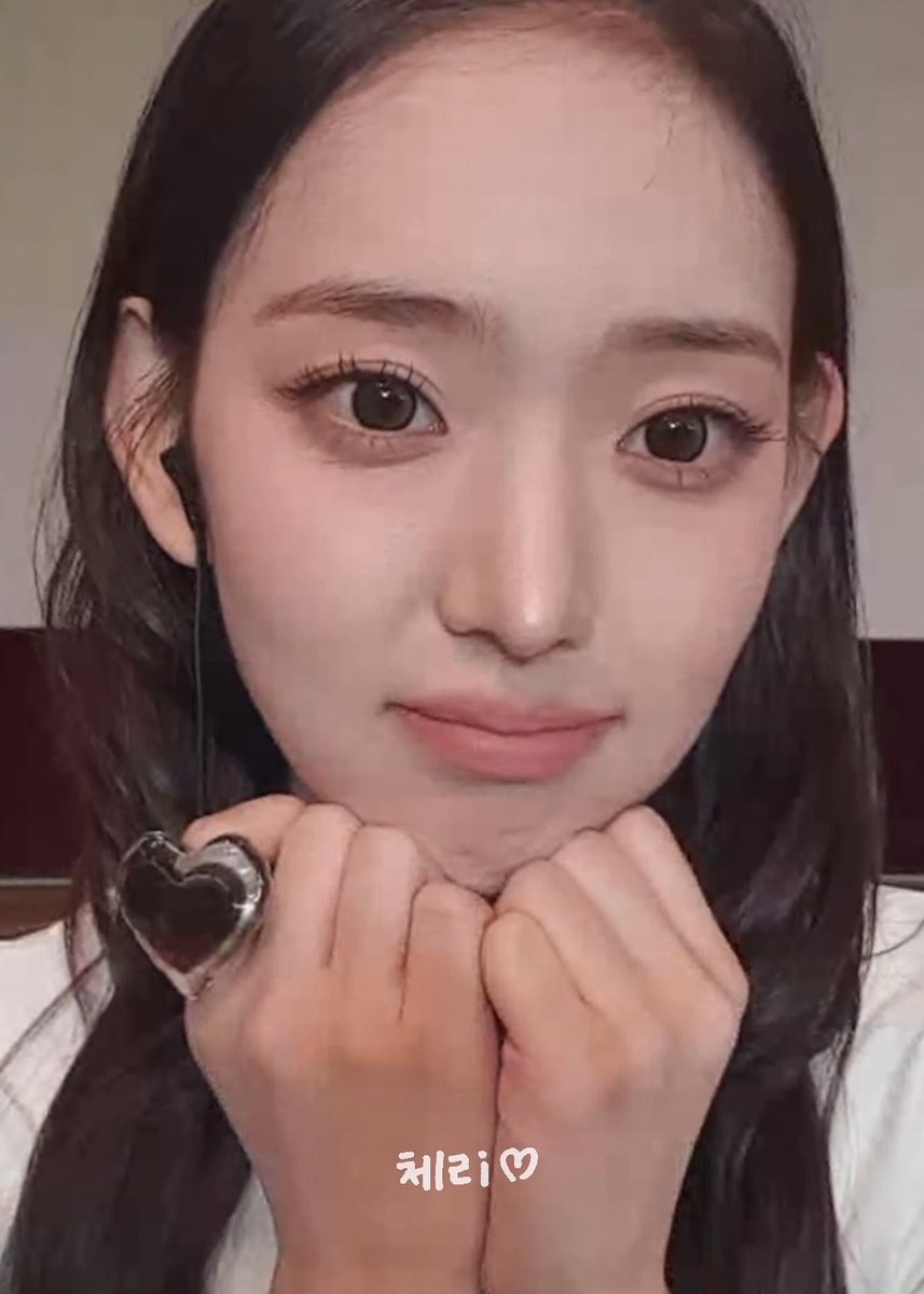 A close-up selfie of a young woman with long dark hair resting her chin on her clasped hands, wearing a large heart-shaped ring, with Korean text '체리♡' (Cherry) overlaid.