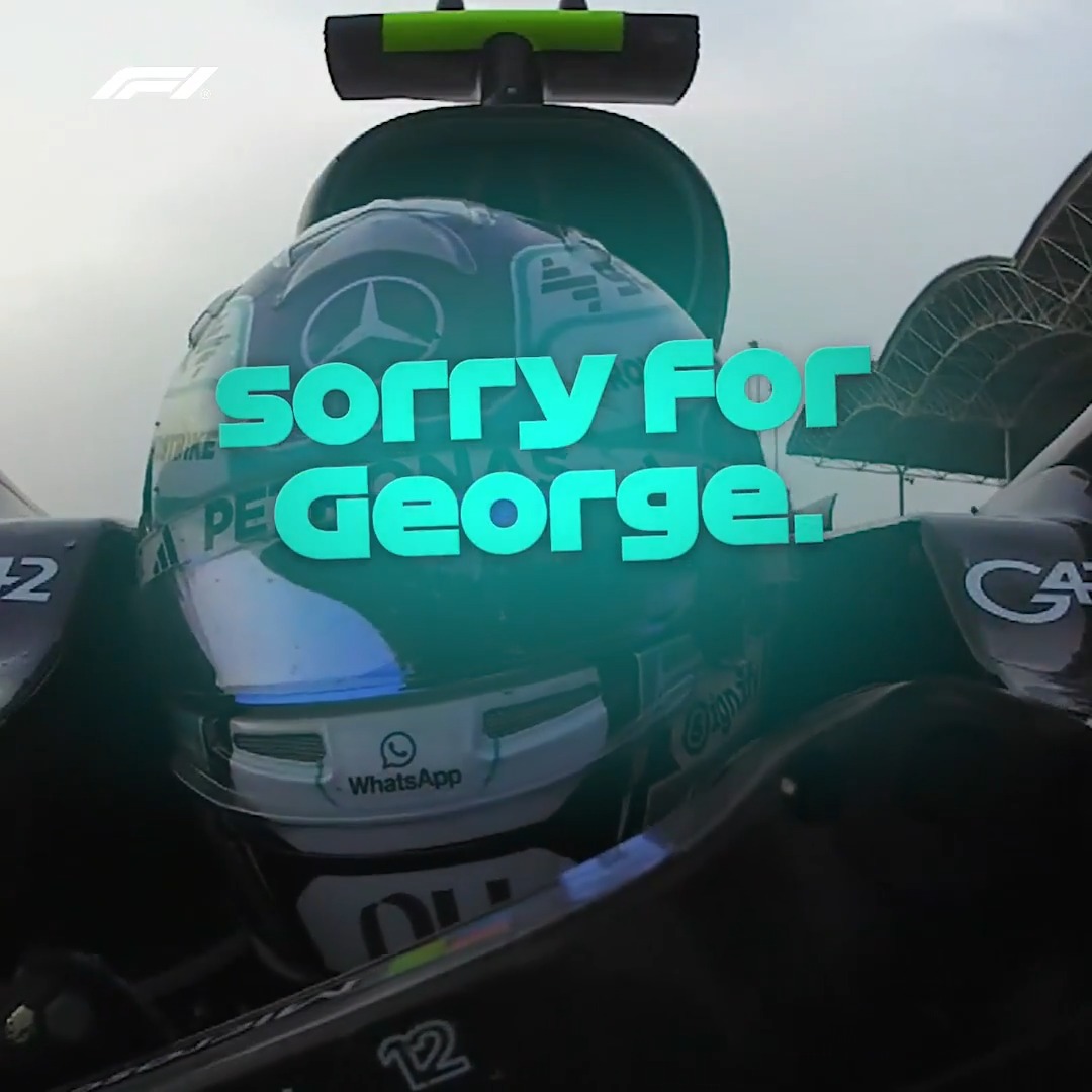 A close-up shot of a Mercedes F1 driver's helmet in the cockpit displays the text "SORRY FOR GEORGE.." in bold teal lettering, referencing a post-race apology to teammate George Russell. Visible branding includes Mercedes, WhatsApp, and the F1 logo, capturing the driver's remorse after the Bahrain Grand Prix.