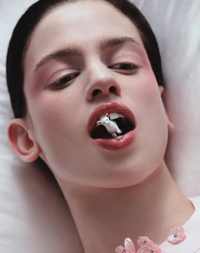 A close-up beauty shot by Aytekin Yalçın features a model with soft pink eyeshadow and glossy lips holding a delicate flower in her mouth, capturing the dreamy, feminine aesthetic the photographer is known for. The "Happy Sunday" post reflects his signature ethereal, artistic portrait style.