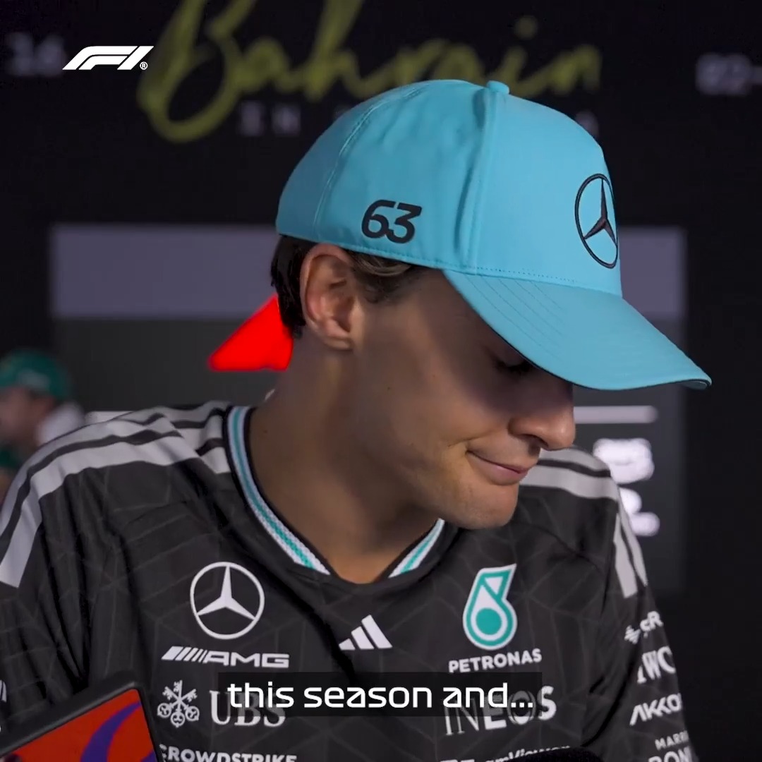 George Russell, wearing his Mercedes team cap with the number 63, looks down with a disappointed expression during a post-race interview at the Bahrain Grand Prix, with "Bahrain" signage and the F1 logo visible in the background.