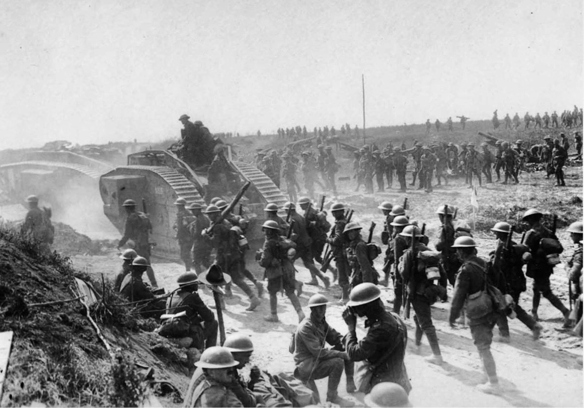 TheWorldatWar2's tweet photo. Allied troops advance on Bapaume, France,1917 with tanks,field guns&mortars. Some of the soldiers rest beside the road near a rough wooden cross topped with an Australian or New Zealand service hat #ww1 #worldwar1 #bapaume #france #1900s #history https://t.co/xHUJRqdq2Q