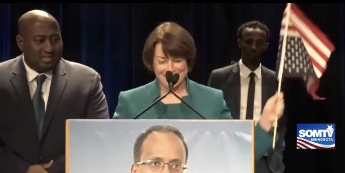 proamericapol's tweet photo. 🚨JUST IN: Amy Klobuchar waves an UPSIDE DOWN American flag while promising to make it easier for fraudsters to wire money out of the country.

Realize where we are. 👇 https://t.co/MqMUzSlGLd