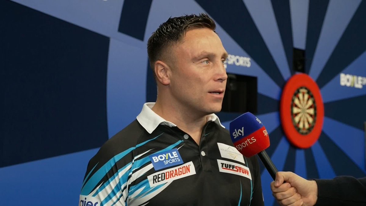 Professional darts player Gerwyn Price being interviewed by Sky Sports in front of a dartboard, wearing a shirt with "BOYLE SPORTS," "REDDRAGON," and "TUFFSTUFF" logos.