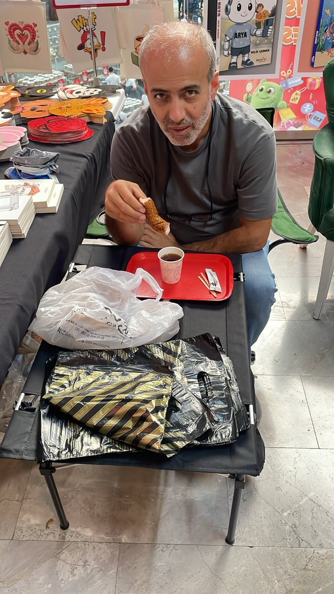 yayder930's tweet photo. Kitapların arasında kısa bir öğle molası: simit ve çay. Yayıncı arkadaşımızın bu fotoğrafı, sektörün geçim sıkıntısını anlatıyor. Kitabı basmak, taşımak ve okura ulaştırmak için çalışan yayıncılar, artan giderler karşısında kendi öğünlerinden tasarruf eder hale geldi. https://t.co/prhc3i3m9x