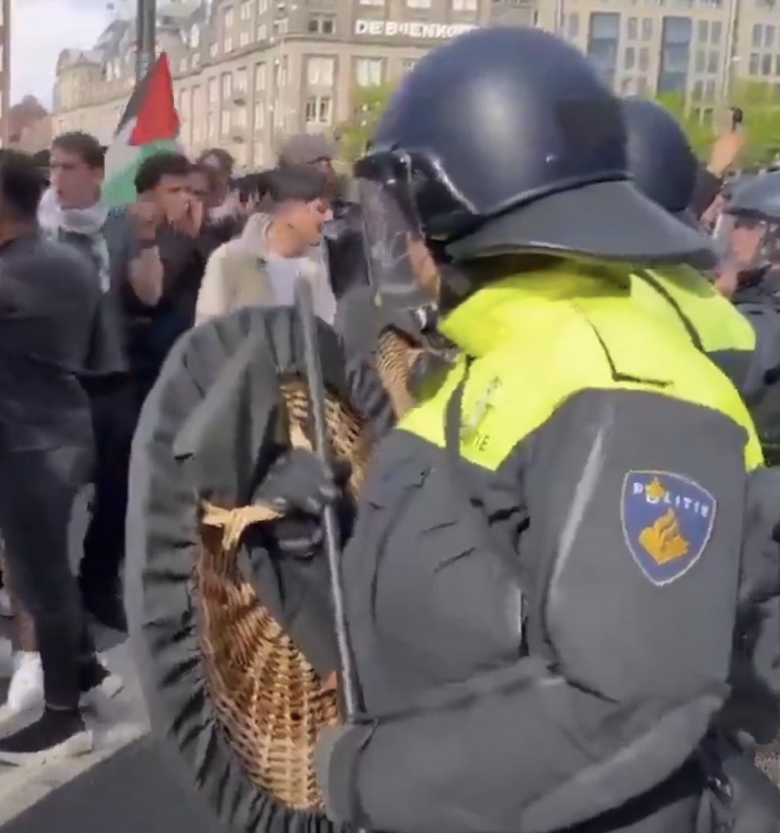 Systemkratzer's tweet photo. Der Niederländische Staat schickt seine Polizei mit einem Korb auf die Straße.

@POL_Amsterdam, volle Montur, „POLITIE“ auf der Weste, Helm, Visier, Schlagstock. 

Und davor ein geflochtenes Rundschild, das auf dem Markt die Tulpen trägt. 

Splitterschutz aus Peddigrohr. 
Wer das ausgibt, hat die Polizisten schon abgeschrieben, bevor der erste Stein fliegt.

👉🏻 Der Korb ist eine Entscheidung.👈🏻

Jemand hat ihn bestellt, jemand hat ihn bezahlt, und jemand hat beschlossen, dass das als Schutz reicht.🤦🏻‍♂️

Dann sieht man, was der Staat 🇳🇱 seinen eigenen Leuten zugedacht hat: ein Picknickkorb als Schutzschild. 

‼️😂🇳🇱😂‼️

#Politie #Niederlande #Holland