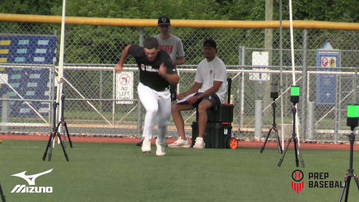 A baseball player completes a sprint drill at what appears to be a Prep Baseball showcase event, with scouts and timing equipment visible.