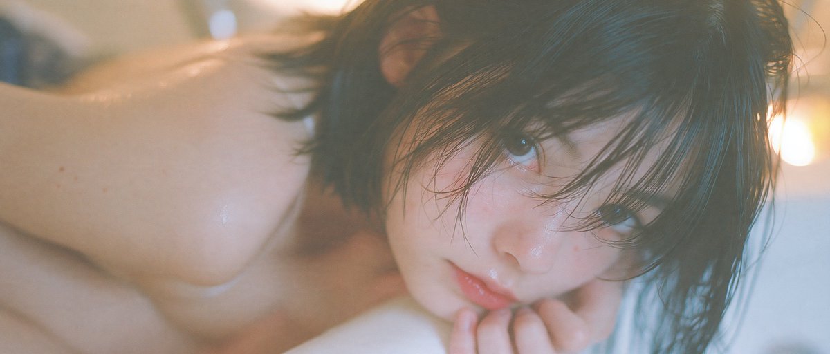 VIBEQUIRKLABS's tweet photo. Midjourney V8.2 :
Photorealistic editorial portrait. A 20 year old Japanese woman, soft oval face, gentle almond eyes, natural brows, small nose, softly defined lips, soft smile, sleek wet black bob. Tall slender figure. Prone in an empty dry bathtub, torso face down, body deeply curled, knees drawn to chest, spine rounded compact, one hand beside face, other arm along body. Wears silk camisole and balloon cargo pants. Seamless saturated pure purple background and ground blending into a continuous purple void, no corners. Warm low light amber interior, hard direct on camera flash, bright highlights, crisp compact shadows. Inspired by Rinko Kawauchi: airy high key, pale overexposed daylight, cool pastels, delicate everyday realism. 85mm f/2.0, compressed perspective, shallow depth of field, optical vignetting. Early 2000s compact digital CCD rendering, on camera flash glare, low resolution softness, narrow dynamic range, clipped highlights, crushed noisy shadows. --chaos 20 --ar 7:3 --raw --stylize 600 --hd --sref 2622630702 596794171 --profile dfe7kdu pt7d7m1