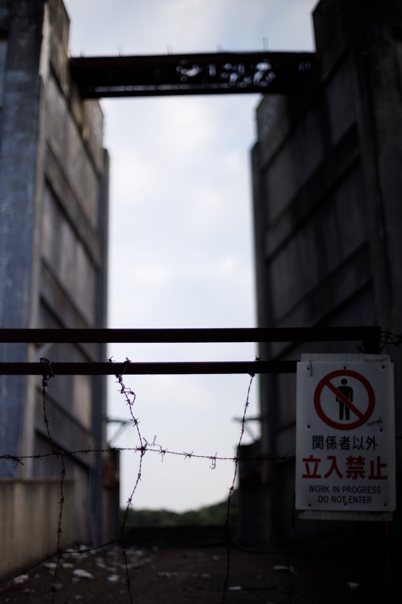 battenkusa's tweet photo. そして池島廃墟群のボス、8階建てアパート群。
夕方に訪れたので威圧感がすごい。
エレベーターが無いために独特のギミックを備えていて、裏側の高台から5階にアクセスできるようになっているそうで、5～8階の住人はそこから入れば簡単アクセスできるようになっているらしい。最上階渡り廊下も見えるね、スリル満点そうだけど。