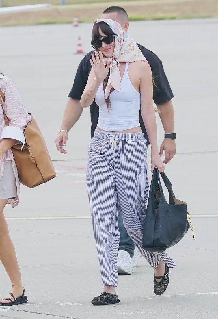 Nandacarneiro23's tweet photo. Seeing these first two photos and what a wonderful day when our princess Dakota Johnson left her vacation in the Mediterranean for the Karlovy Vary/2025 film festival. And she got there like this.. completely a Hollywood muse with her scarf on her head. I'm completely in love when Dakota wears these handkerchiefs. Things of a Hollywood diva 🥰👑