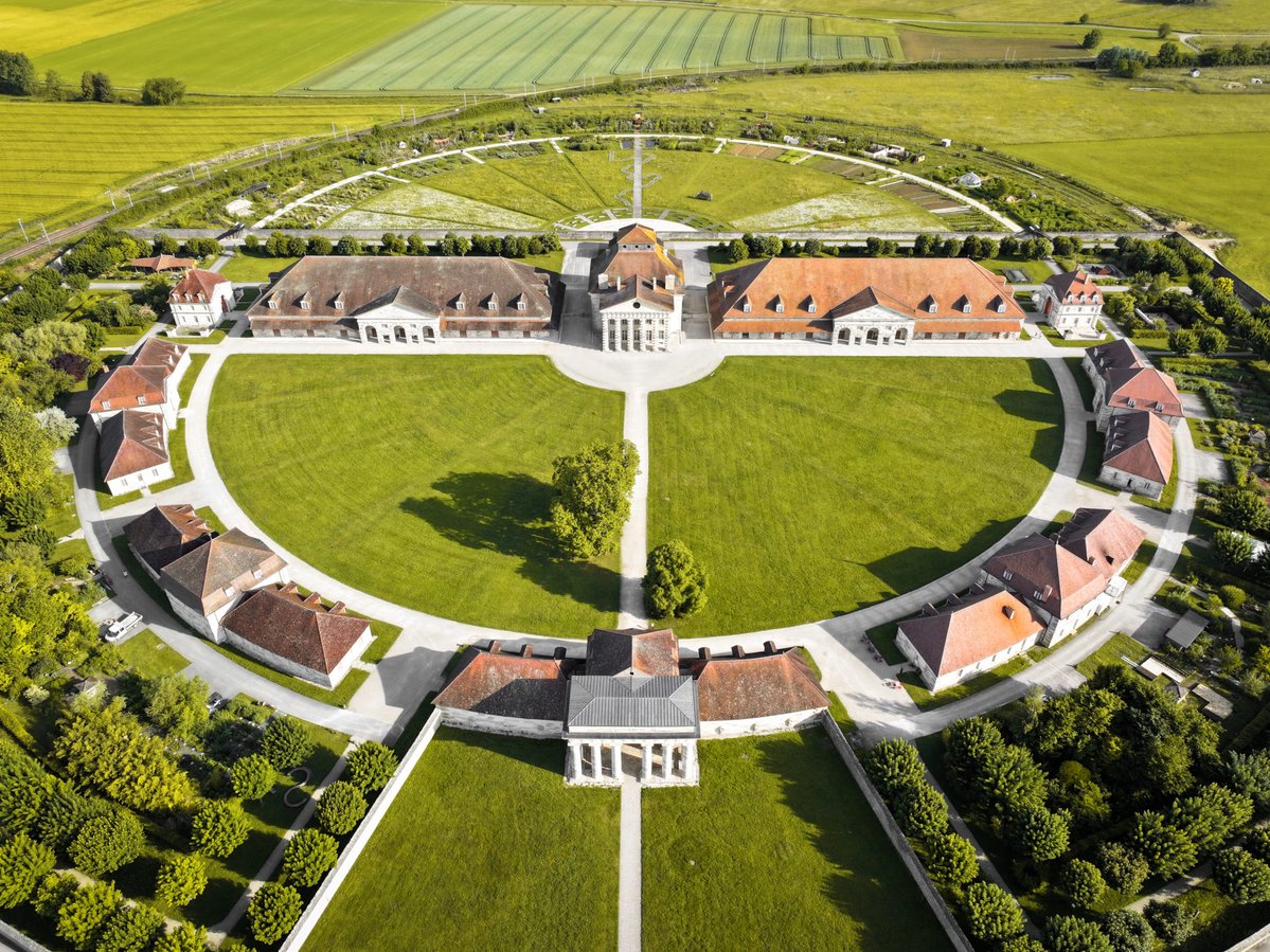 CeJourHistoire's tweet photo. Cette usine du Doubs a été dessinée comme un palais. Pendant 115 ans, son eau salée est arrivée par 21 kilomètres de tuyaux en bois.

C'est la Saline royale d'Arc-et-Senans. Elle est classée au patrimoine mondial de l'Unesco depuis 1982.

Au XVIIIe siècle, le sel sert à conserver la viande et le poisson. Le roi le taxe lourdement, c'est la gabelle.

À Salins, dans le Jura, l'eau qui sort du sol est chargée de sel.

Pour en tirer le sel, on la fait bouillir. Il faut des quantités énormes de bois.

Les forêts autour de Salins s'épuisent. Alors on décide d'amener l'eau jusqu'au bois.

En 1773, Louis XV signe l'édit. L'usine sera construite à Arc-et-Senans, au bord de la forêt de Chaux.

L'architecte s'appelle Claude-Nicolas Ledoux. Il dessine les bâtiments en demi-cercle.

Au centre, la maison du directeur. Autour, les ateliers où l'on fait bouillir l'eau, et les logements des ouvriers.

Ledoux voit plus grand. Le demi-cercle doit devenir un cercle complet, une ville idéale autour de l'usine.

Cette ville ne sera jamais construite.

À partir de 1780, l'eau salée arrive de Salins par un tuyau de bois de 21 kilomètres.

En route, une partie se perd, par les fuites et par les vols. Jusqu'à 30 %.

En 1895, l'usine ferme. L'eau salée n'arrive plus en quantité suffisante, et les voisins l'accusent de polluer leurs puits.

En 1926, une partie des bâtiments est dynamitée. Le département du Doubs rachète le site l'année suivante.

Le demi-cercle de Ledoux attend sa seconde moitié depuis 250 ans.