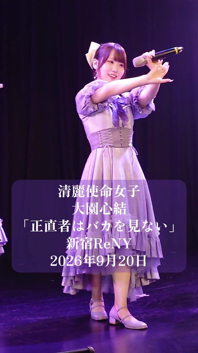 A performer on stage wearing a lavender and white layered dress with a corset-style top, holding a microphone and extending her arm, with a Japanese text overlay identifying her as '清麗使命女子 大園心結' from '新宿ReNY' on '2026年9月20日'.