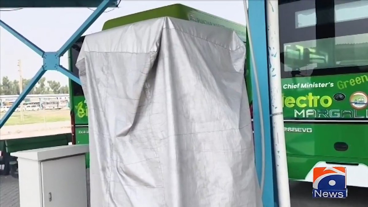 An undraped object covered with a white sheet stands at what appears to be an inauguration event, with a green bus labeled "Chief Minister's Green Electro Marga" visible in the background. The Geo News watermark is in the corner.