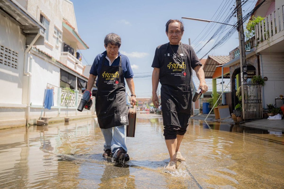 Mirror_org's tweet photo. ชายสูงวัย 2 คนพาตัวเองออกมาจากงานซ่อมเครื่องใช้ไฟฟ้าที่มูลนิธิกระจกเงา ในนามทีม "ช้าการข่าง"
.
ชายทั้ง 2 รอวันน้ำลด เพื่อที่ตัวเองจะออกมาช่วยเหลือบ้านช่องที่เครื่องใช้ไฟฟ้าเสียหาย ตู้เย็น เครื่องซักผ้า และปั๊มน้ำ
.
พวกเขากำหนดพื้นที่ลงเช็กและซ่อมแซม ในที่หมู่น้านหนึ่งแถวร่มเกล้า บางวันได้อาสามาช่วยประมาณ 2-3 คน
.
บางวันทั้ง 2 ก็ลุยเดี่ยวลงไป ภายใน 3 วันซ่อมเครื่องใช้ไฟฟ้าดังว่าไปแล้ว 50 หลังคาเรือน
.
แต่ก็ต้องเบรคตัวเลขไว้ที่เท่านี้ก่อน ด้วยประเมินแล้วว่า มากไปกว่านี้ พวกแกจะไม่ไหว และ มากไปการช่วยก็จะไม่ได้คุณภาพที่ดีพอ
.
“มันเหนื่อยกว่าทำงานที่ออฟฟิศหน่อยแหละ แต่ก็รู้สึกดี รู้สึกภูมิใจที่ได้มาช่วย จริง ๆ ผมก็คนเปราะบางนะ แต่อาศัยอยู่ในพื้นที่สูงกว่าหน่อย แต่ก็ท่วมเหมือนกันบนถนน หาของกินลำบากมาก 2 วัน แต่ที่นี้ท่วมนานกว่าหนักกว่าเราเยอะ เรามีความรู้ทักษะช่างอยู่ ก็ออกมาใช้มันให้เกิดประโยชน์”
.
ชายชราวัย 67 ให้ปากคำอย่างยิ้มแย้ม
.
“ชีวิตที่เหลืออยู่แค่นี้แล้ว มีกำลังที่จะทำอะไรได้ก็ทำ มันก็คือความจริงของสังคม เราจะปฏิเสธไม่ได้แม้เราจะไม่อยู่ในสภาพแบบนั้น เราเต็มใจที่จะทำในสายงานที่เรามีความรู้ ผมเจอคนหลากหลายตลอดชีวิตการทำงาน ทำให้เข้าใจเรื่องแบบนี้ได้ไม่ยาก”
.
ชายชราวัย 60 ปีให้ปากคำแบบขึงขัง
.
ระหว่างเดินร่วมทางไปกับช่างชราทั้งสอง เราเอ่ยปากเช็กความเหนื่อยอ่อนของพวกแก แต่ 1 ในนั้นบอกกับเราว่า
.
“เดินในหมู่บ้านแค่ไม่กี่ซอยไม่เป็นไรหรอก เราเหนื่อยแต่ก็เหนื่อยไม่กี่วัน คนที่เขาน้ำท่วมลำบากกว่าเราเยอะ“
.
เราค้อมคาระวะให้กับช่างชราทั้งสองคน