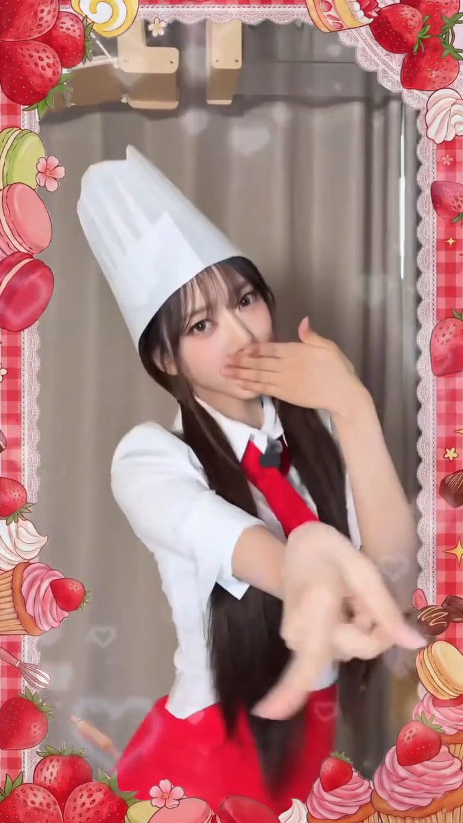 A young woman wearing a white chef's hat and red apron poses playfully, framed by a decorative border featuring strawberries, macarons, and cupcakes.