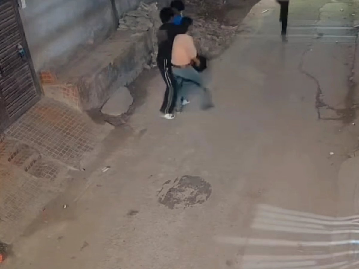 The image shows a surveillance camera view of two individuals struggling on a street, with one appearing to be defending himself against an assault. The caption suggests this footage captured a dramatic moment of self-defense or honor-saving that would otherwise be unbelievable.