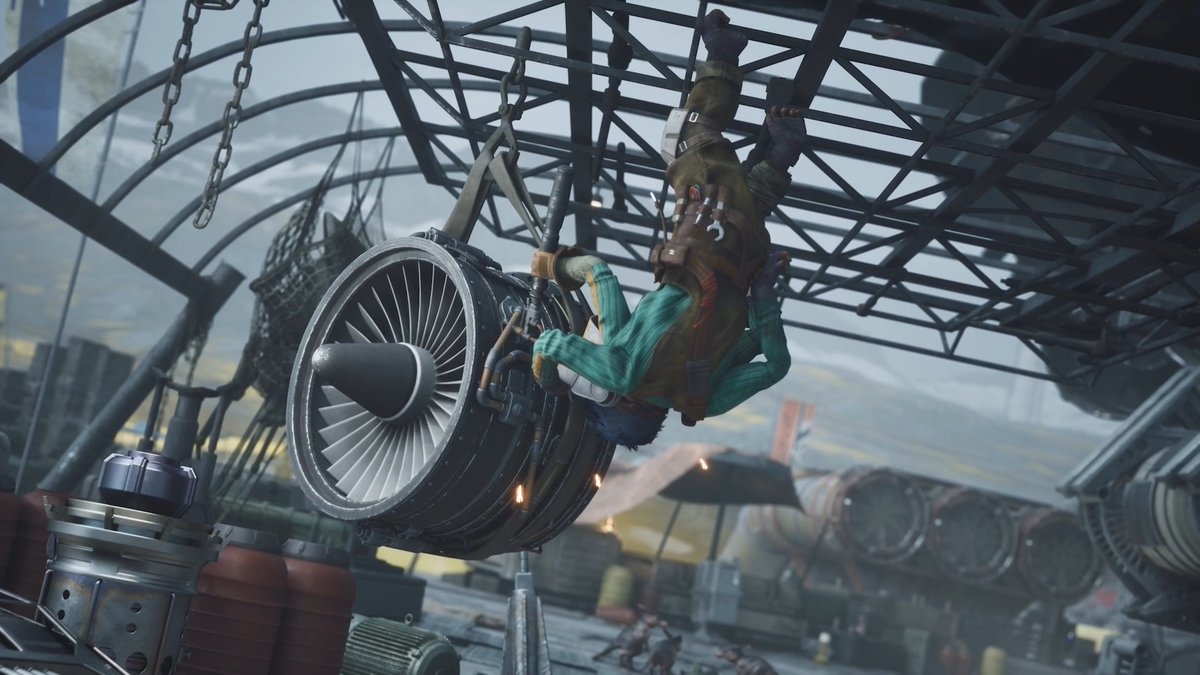 A pilot hangs upside down from the framework of a metallic structure while working on a large jet engine, likely repairing or servicing a speeder bike's repulsorcraft components as part of Star Wars Outlaws' "Under the Hood with Hibi" Episode 2. The gritty, industrial scene showcases the hands-on maintenance involved in mastering the speeder's Kinetic Burst ability mentioned in the accompanying post.