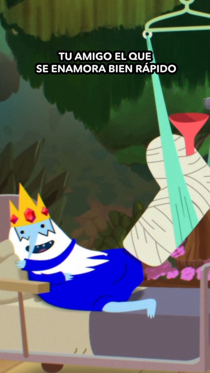 A scene from Adventure Time showing the Ice King (Simon/Ice King) crying dramatically while wearing a red funnel on his head, with Spanish text reading "TU AMIGO EL QUE SE ENAMORA BIEN RÁPIDO" ("Your friend who falls in love really fast") — humorously referencing how the character pines obsessively over Princess Bubblegum, tying into the post's mention of the HBO Max series.