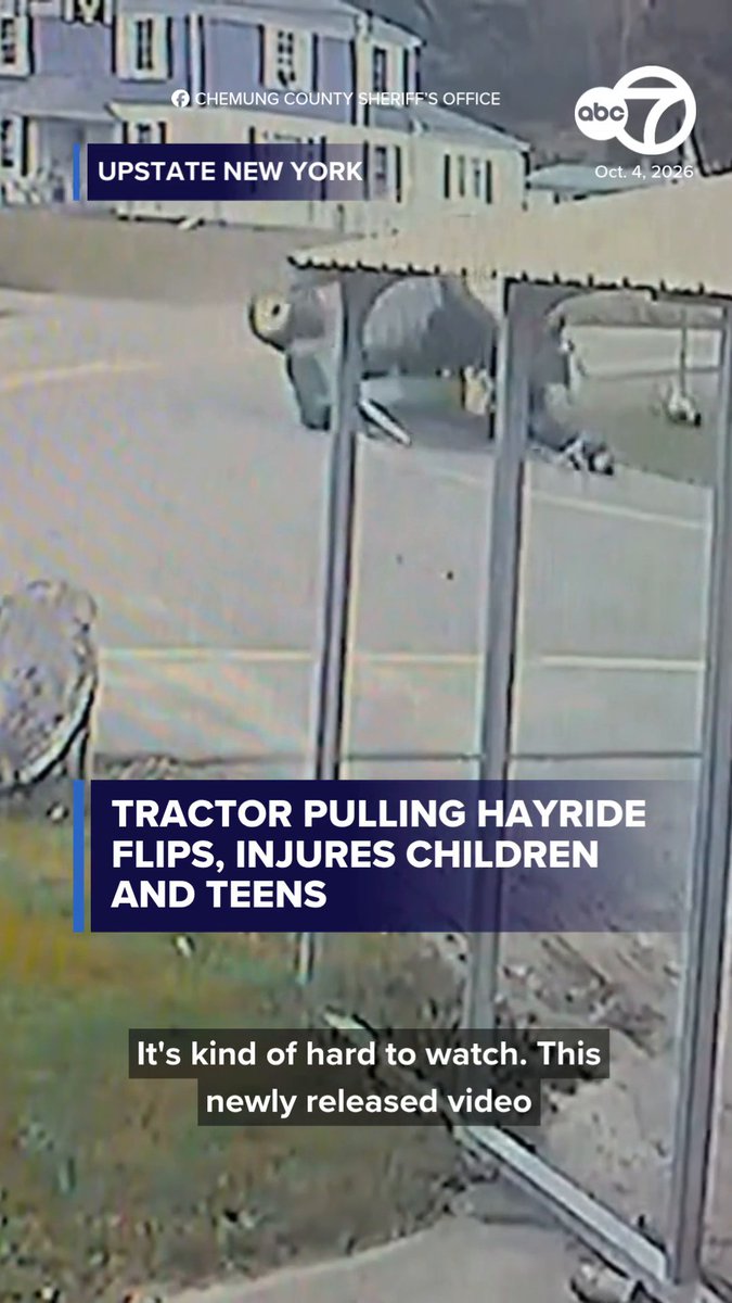 The image shows aerial surveillance footage from the Chemung County Sheriff's Office (dated Oct. 4, 2026) capturing the aftermath of a tractor-pulled hayride that flipped in upstate New York, with the caption "TRACTOR PULLING HAYRIDE FLIPS, INJURES CHILDREN AND TEENS" and the on-screen text "It's kind of hard to watch. This newly released video."