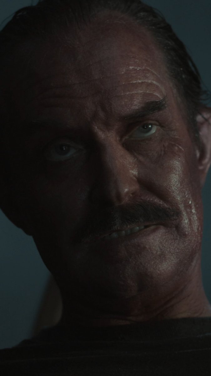A close-up of a man's bruised and sweaty face in dim lighting conveys a tense atmosphere. The post "The color of fear. #Lanterns" suggests this image is from a dark, suspenseful moment in the Lanterns series, with the shadowy lighting reflecting the looming dread referenced in the caption.